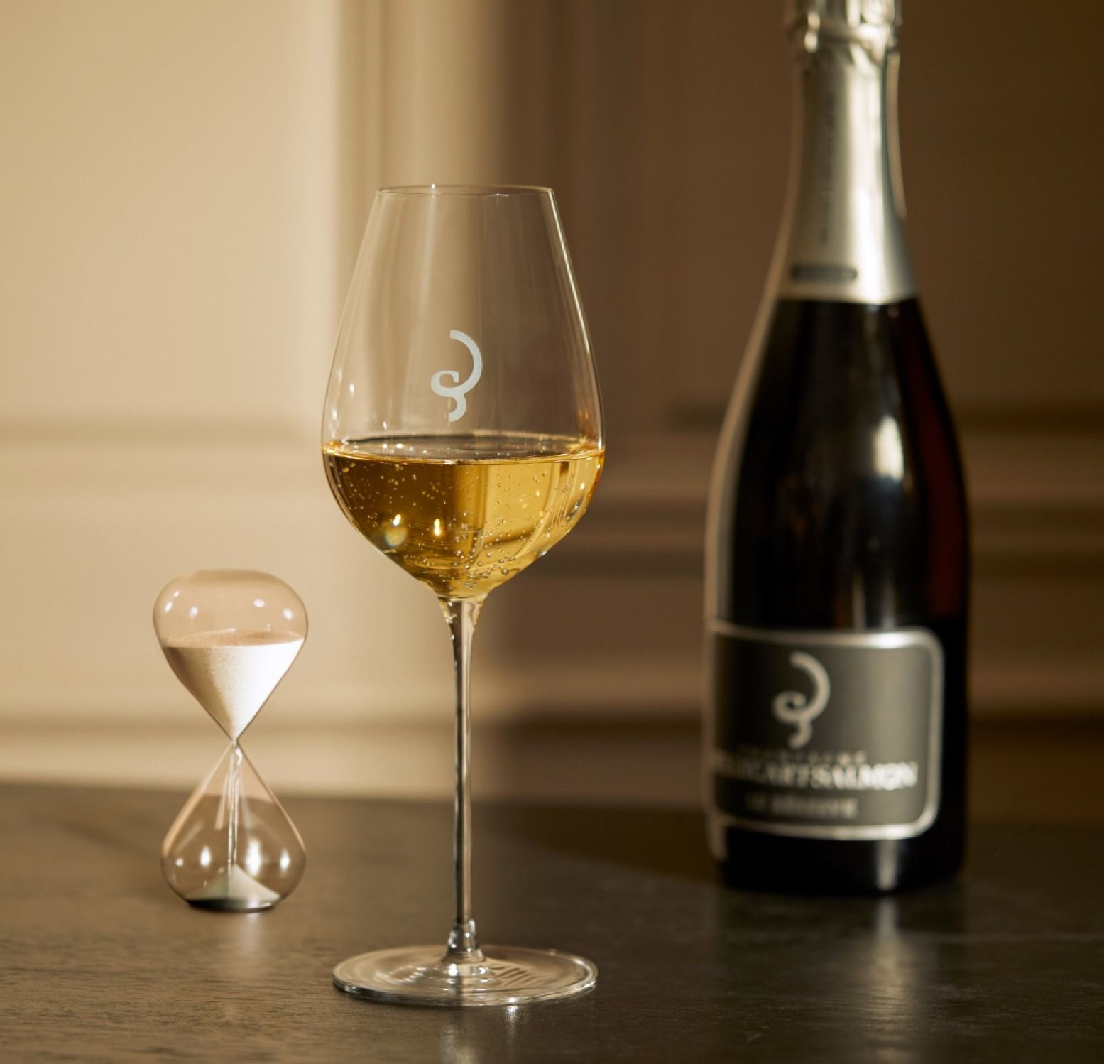 Verre de vin pétillant, bouteille et sablier