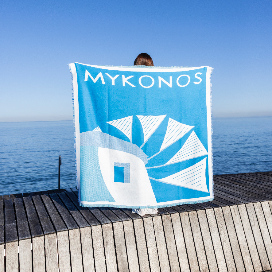 Personne tenant serviette Mykonos face à la mer