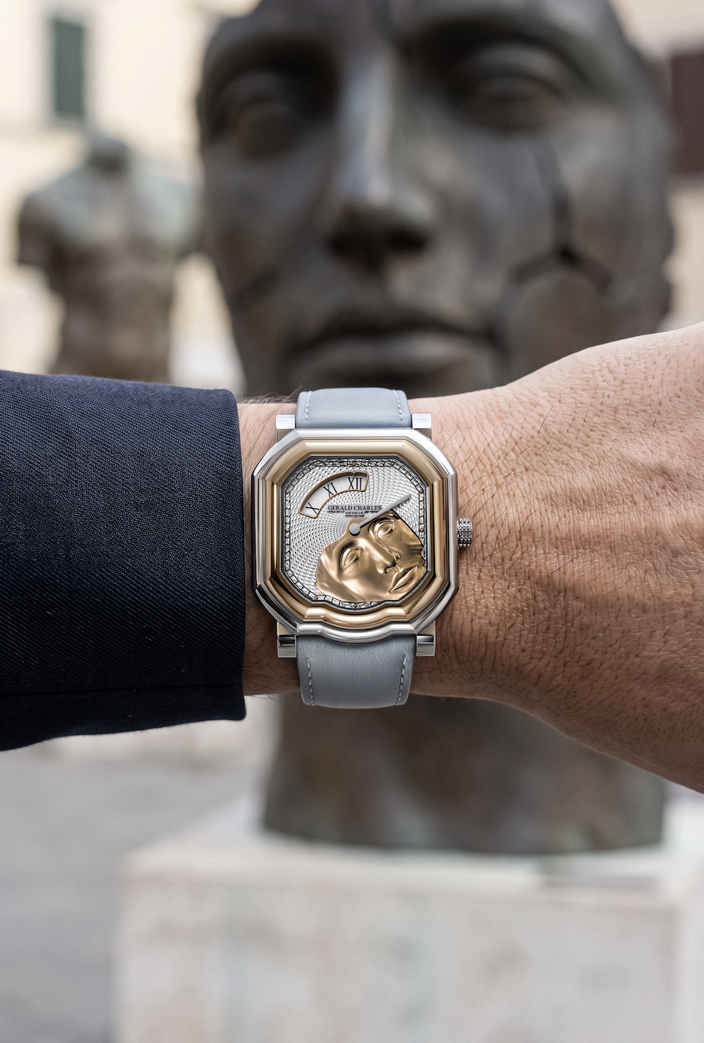 Montre de luxe devant une sculpture monumentale