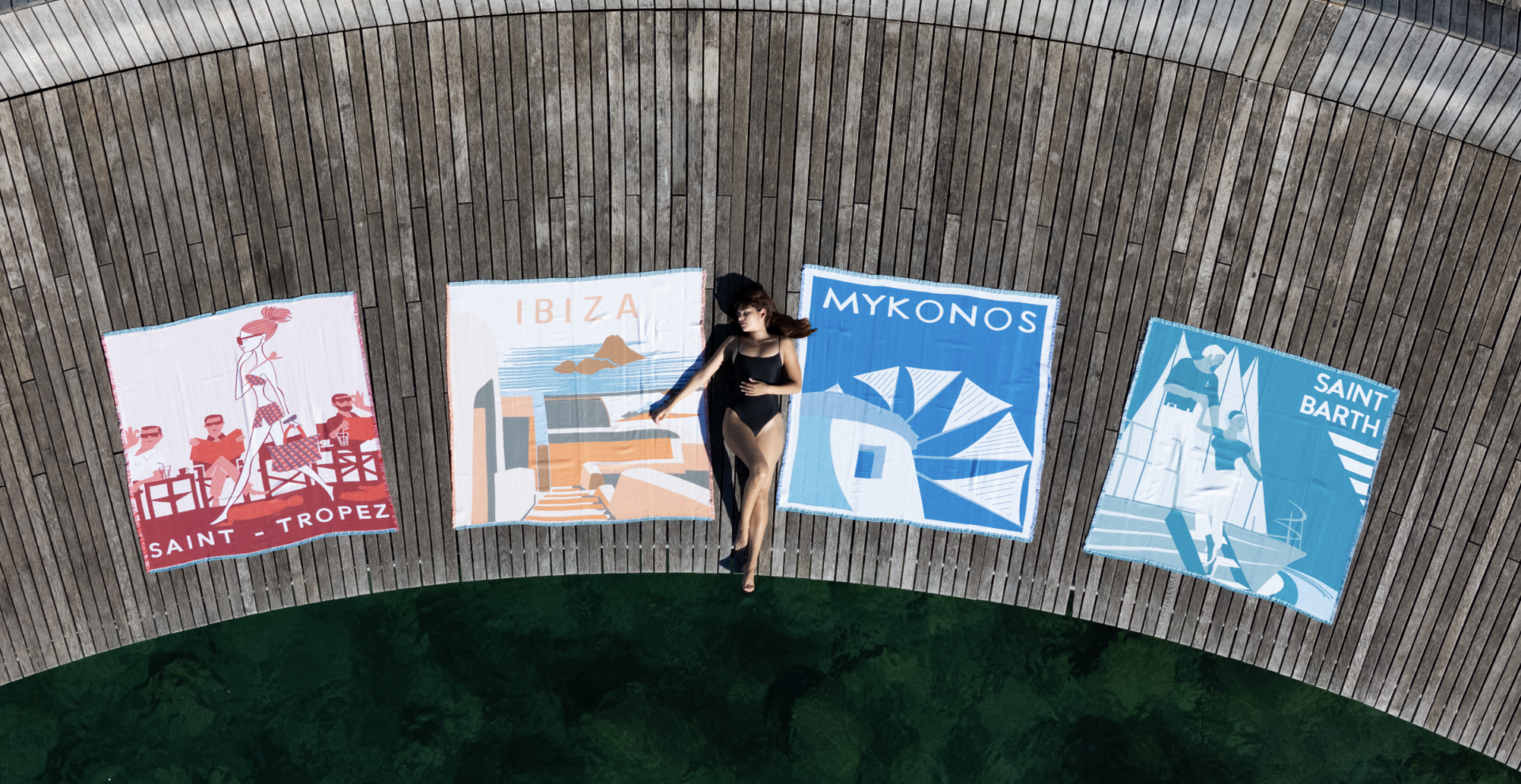 Femme allongée sur ponton entourée de serviettes colorées