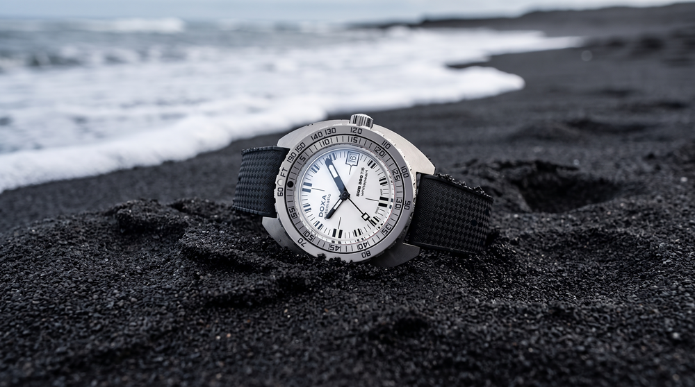 Montre-bracelet posée sur une plage de sable noir