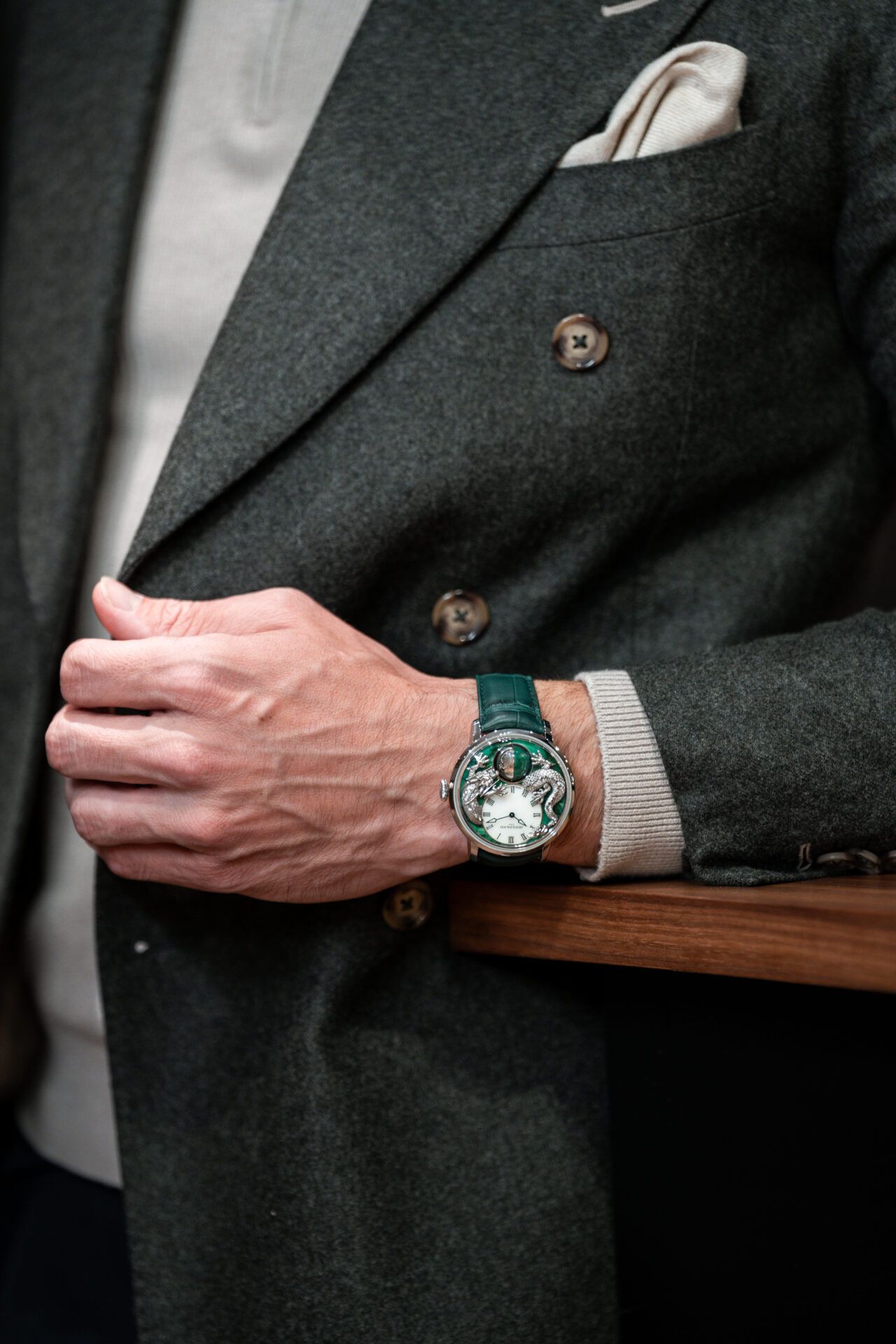 Montre de luxe verte au poignet d’un homme