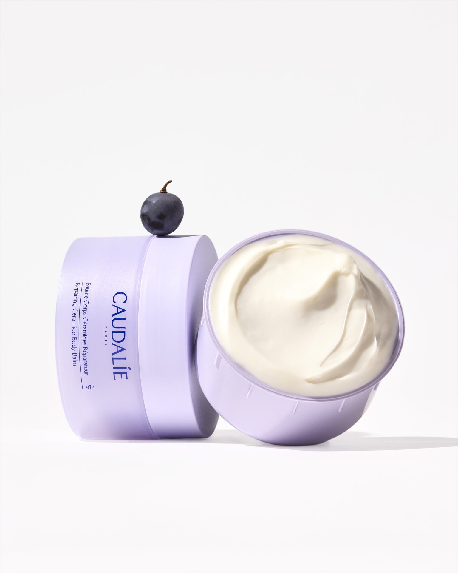 Myrtille posée sur un flacon de crème Caudalie