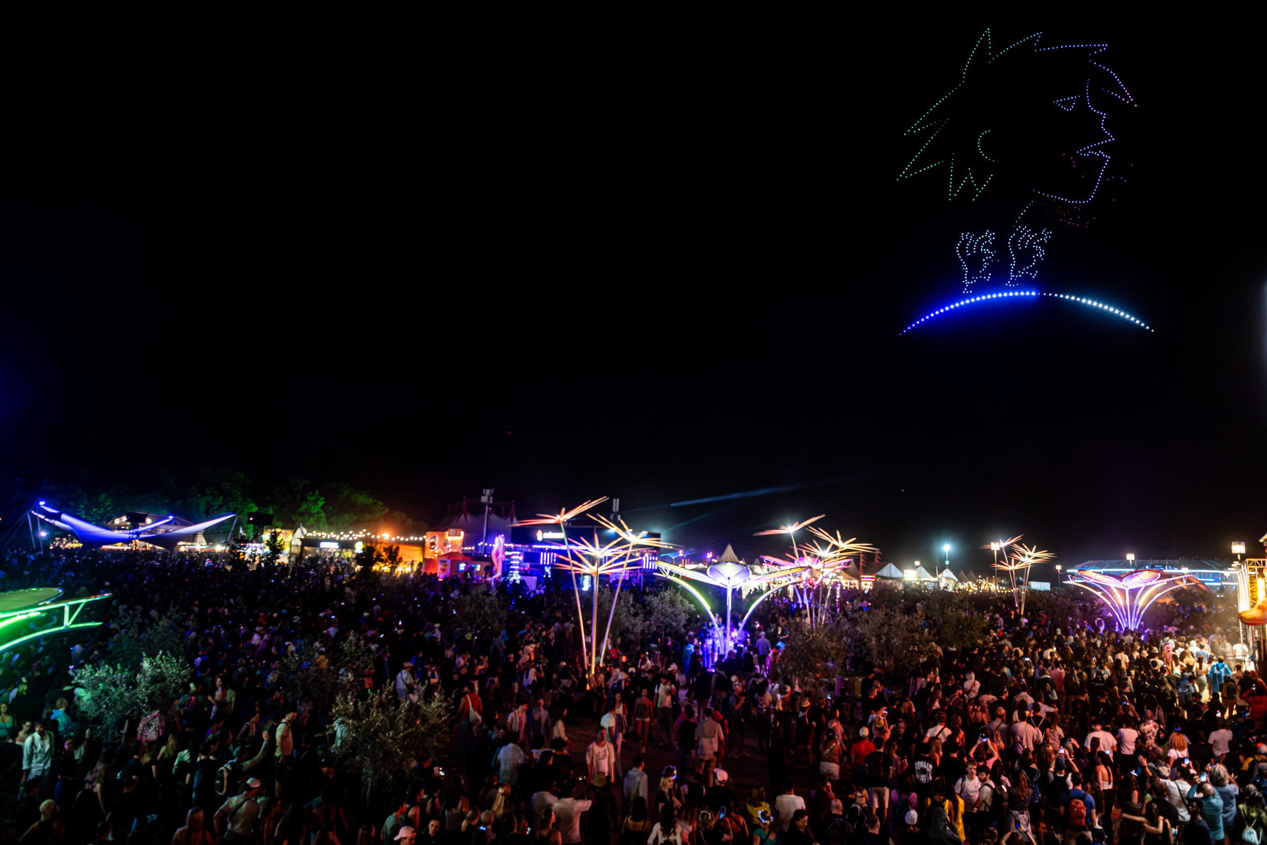 Festival nocturne avec foule et spectacle de drones