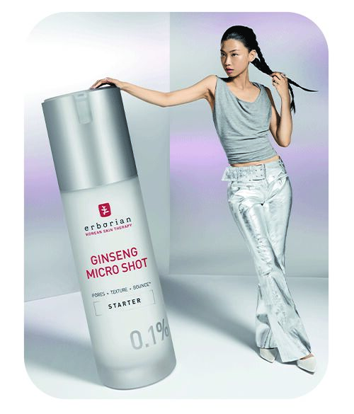 Mannequin posant près d’un flacon géant cosmétique