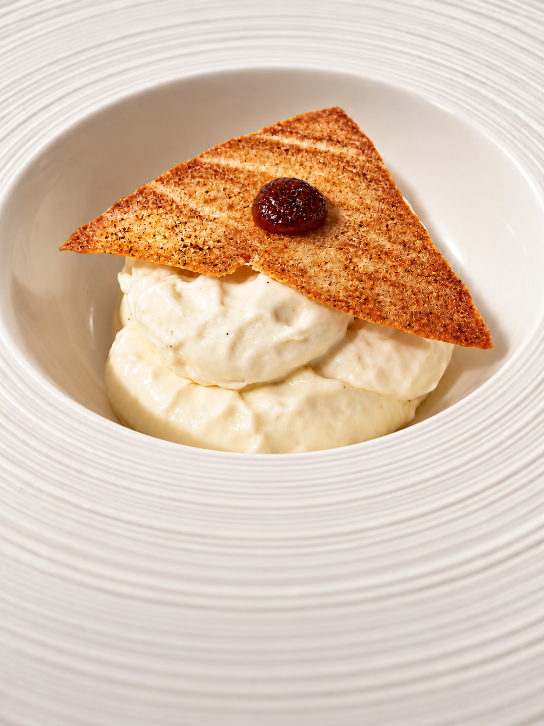 Crème onctueuse surmontée d’une tuile croustillante et cerise