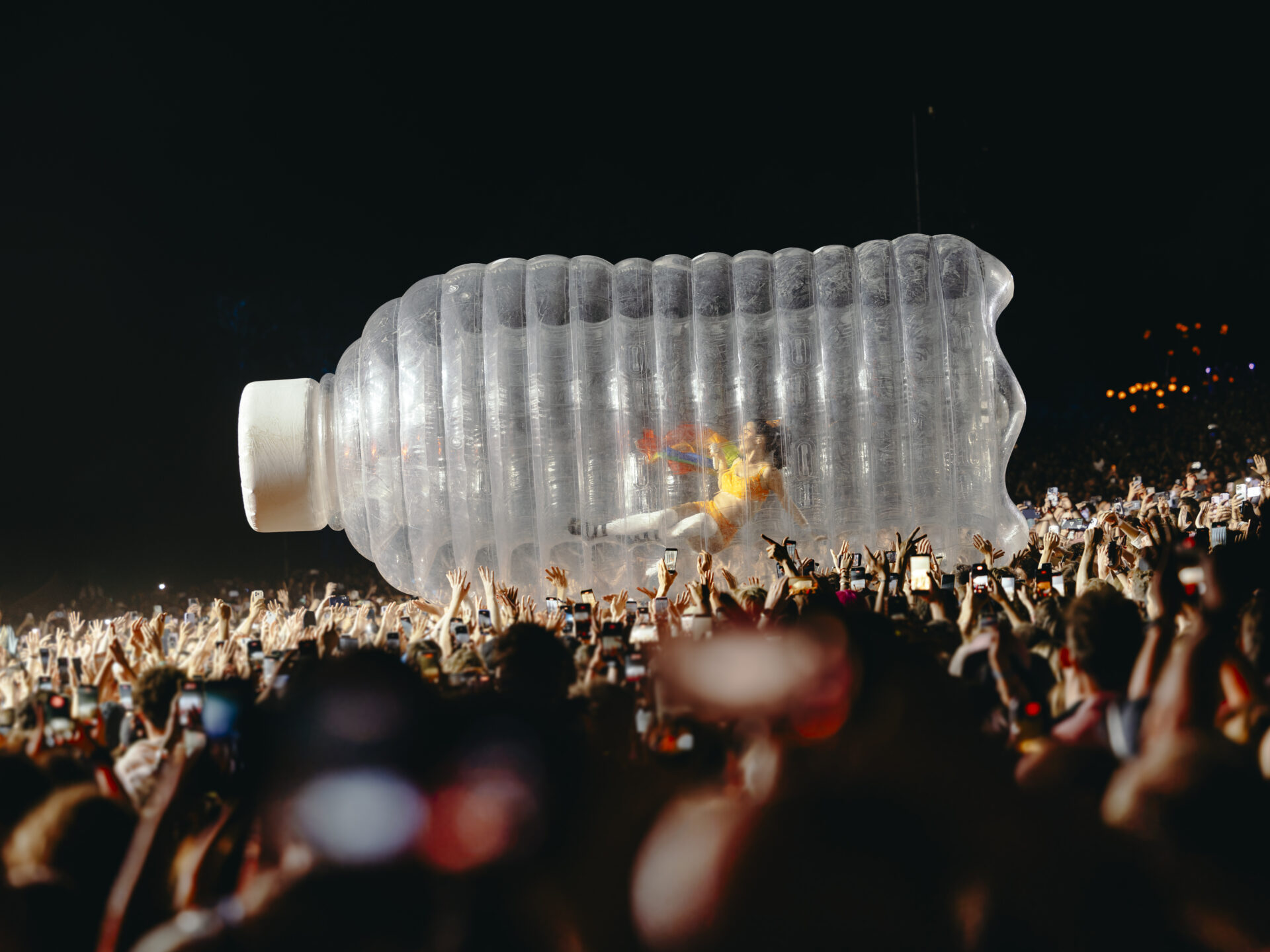 Artiste dans bouteille géante gonflable en concert