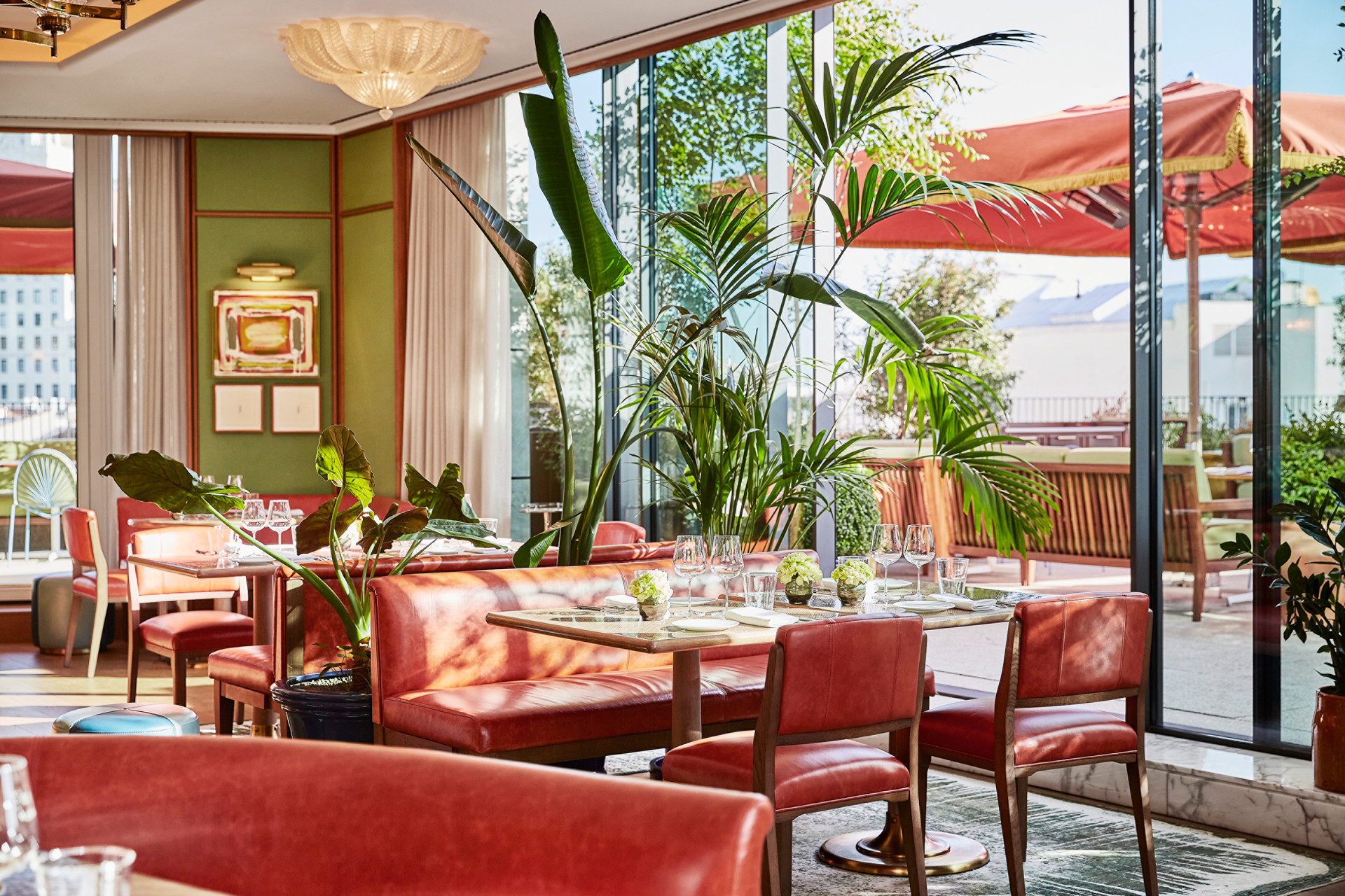 Restaurant lumineux avec banquettes rouges et terrasse