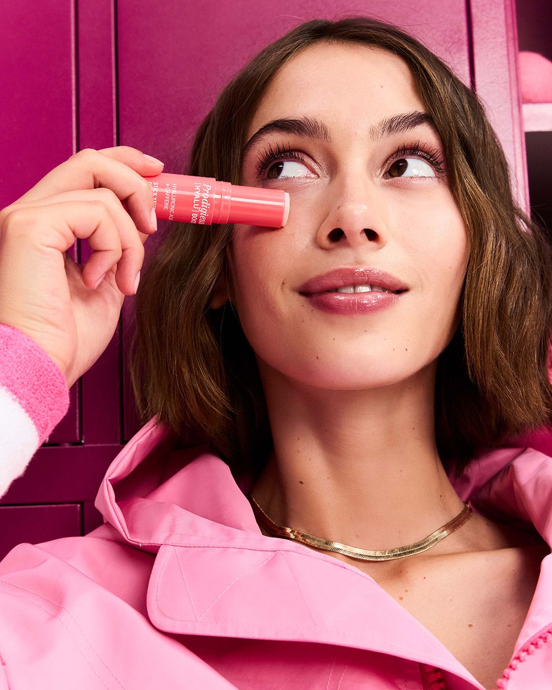 Femme appliquant baume rose près des yeux