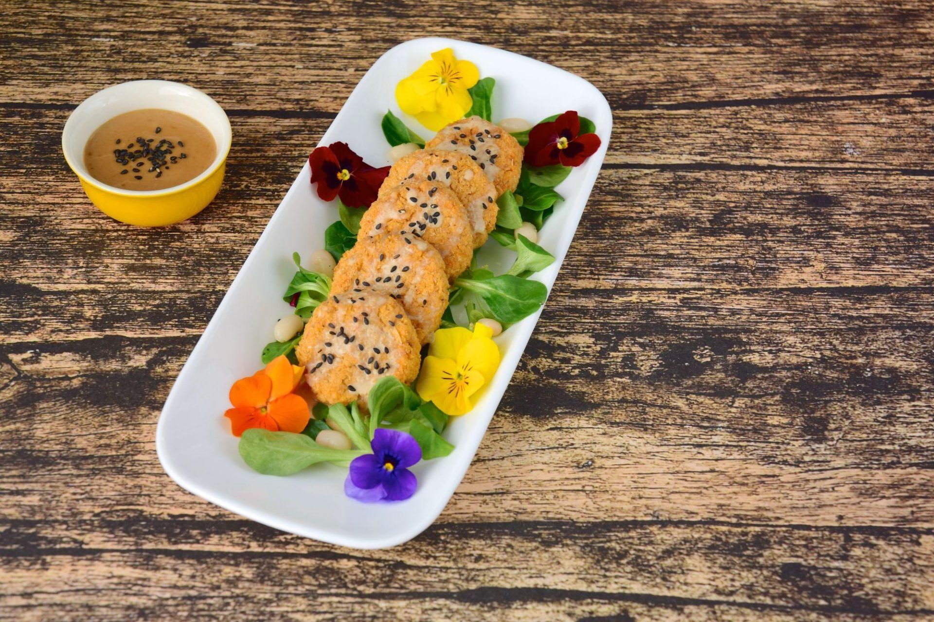 Bouchées panées au sésame, salade et fleurs comestibles