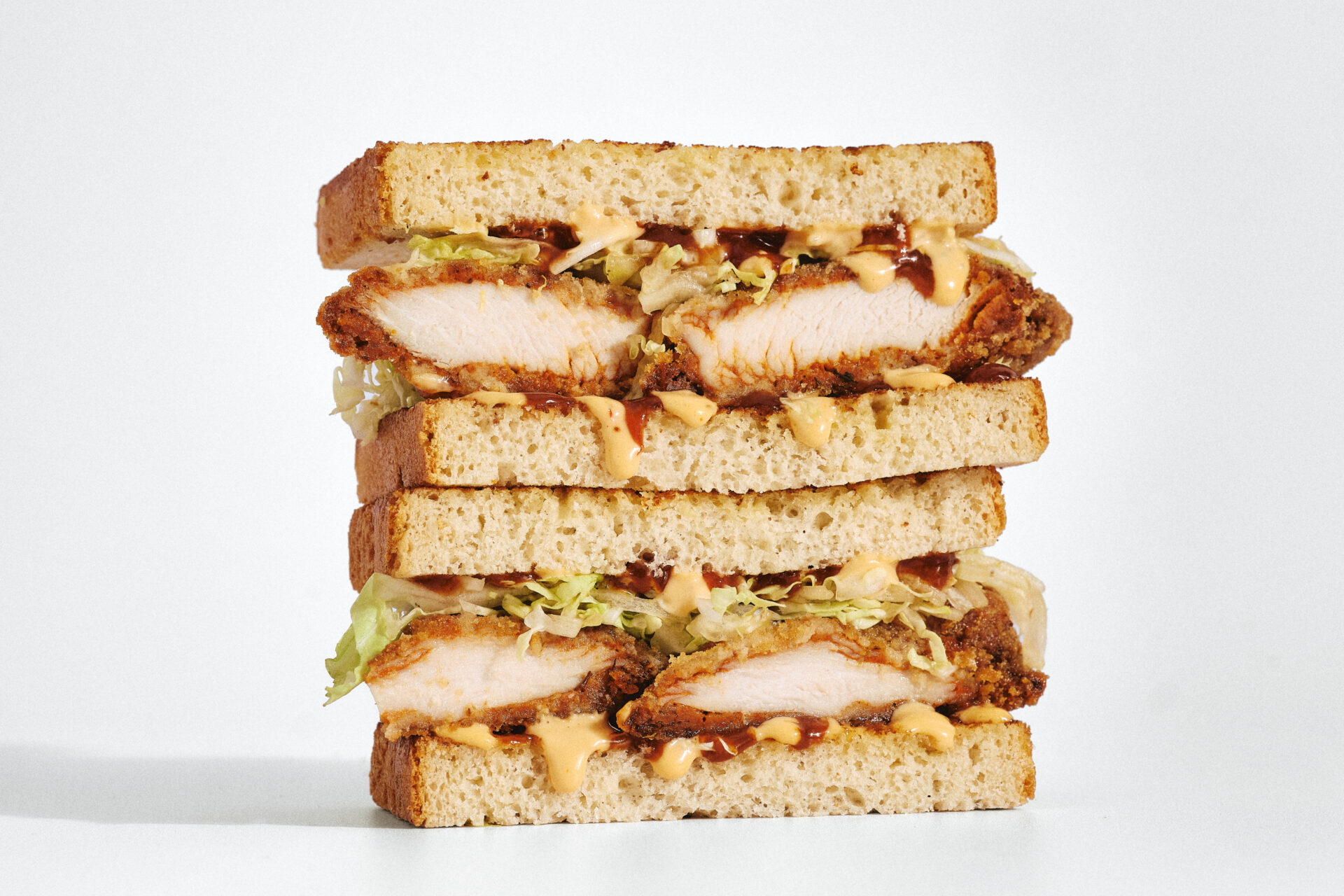 Sandwiches au poulet frit empilés avec sauce