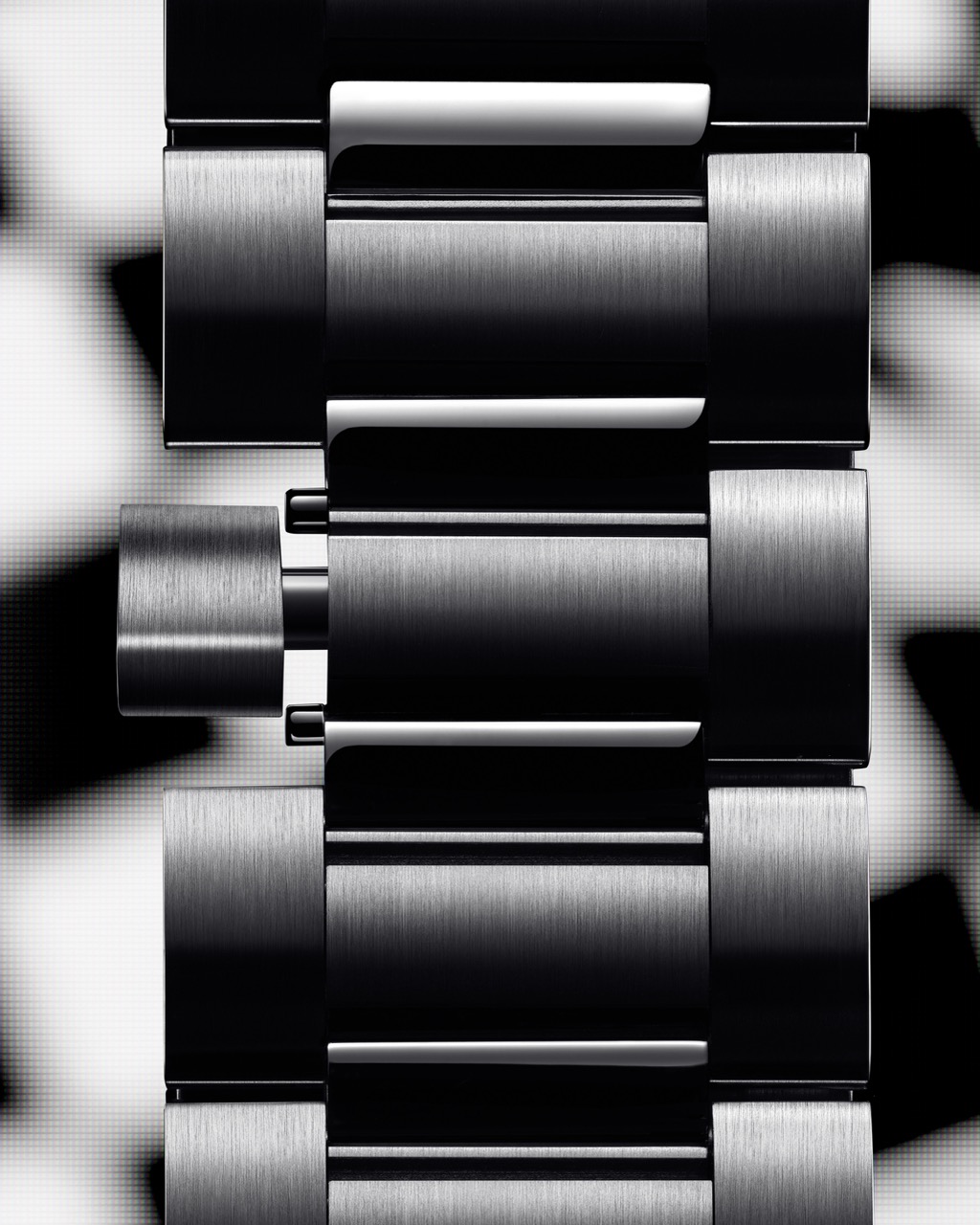 Gros plan d’un bracelet de montre métallique noir et argenté