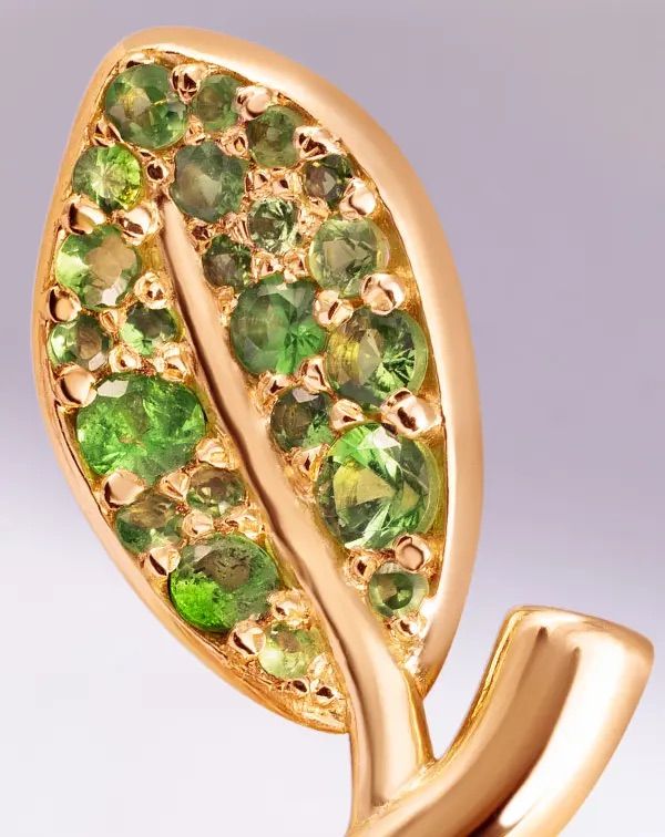 Boucle d’oreille dorée sertie de pierres vertes