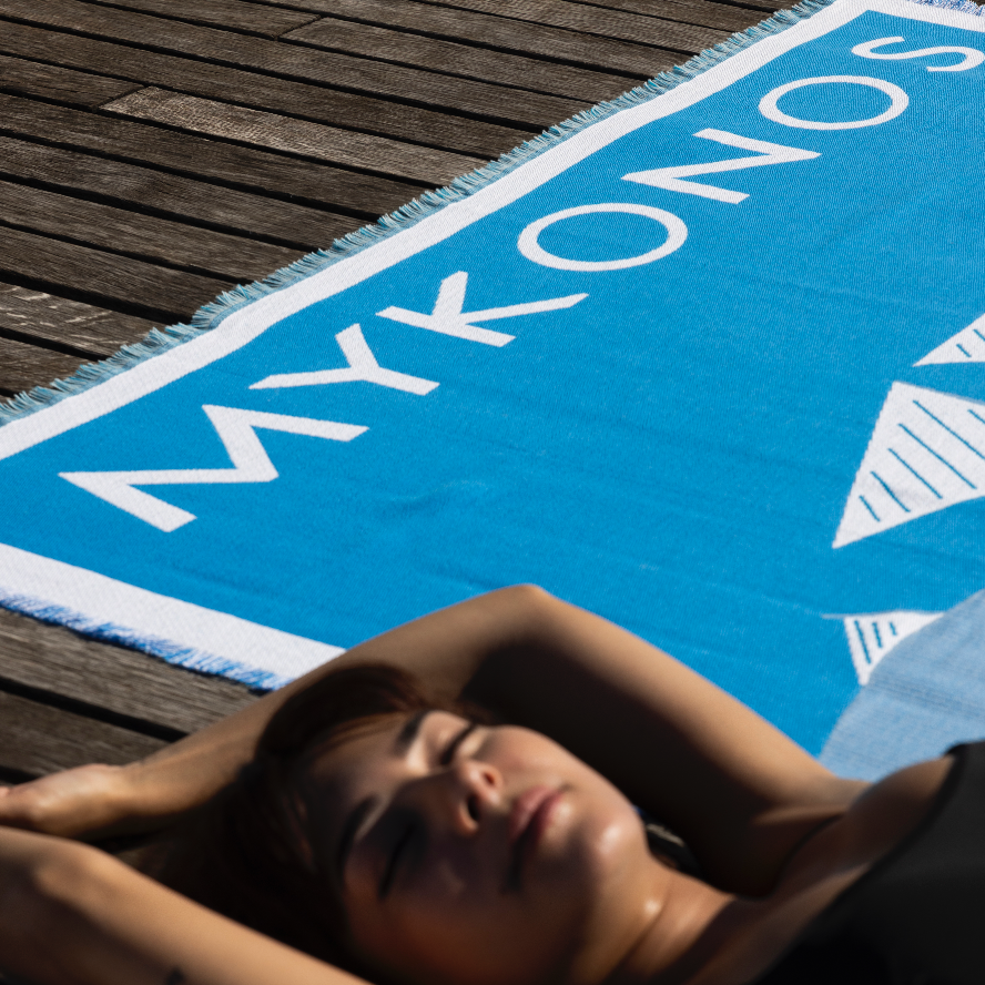 Femme allongée sur serviette Mykonos bleue