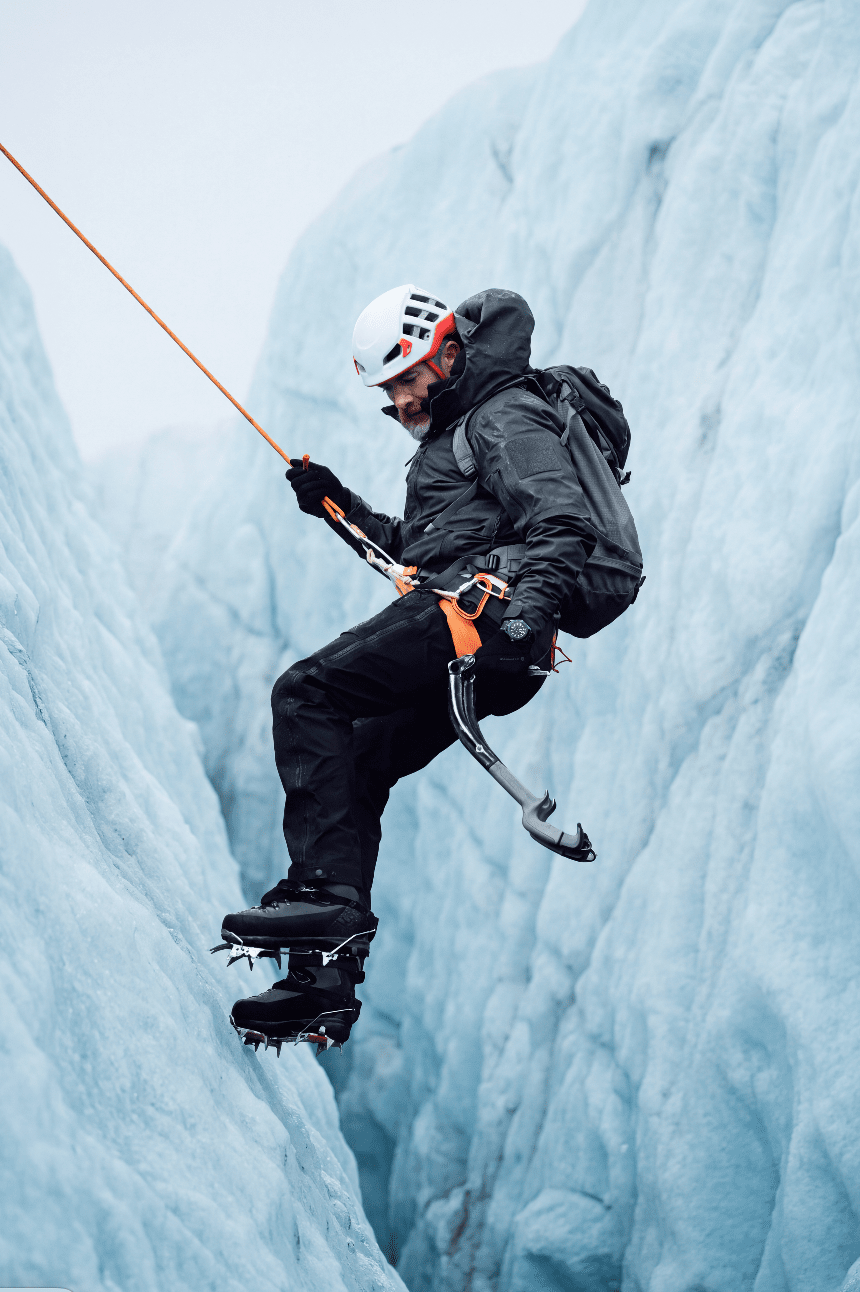 Alpiniste équipé escaladant une paroi de glace