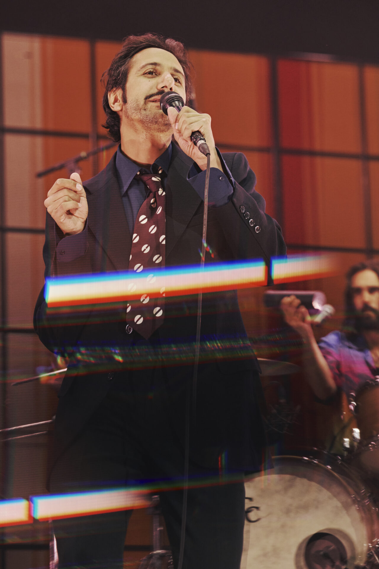 Chanteur en costume sur scène avec micro