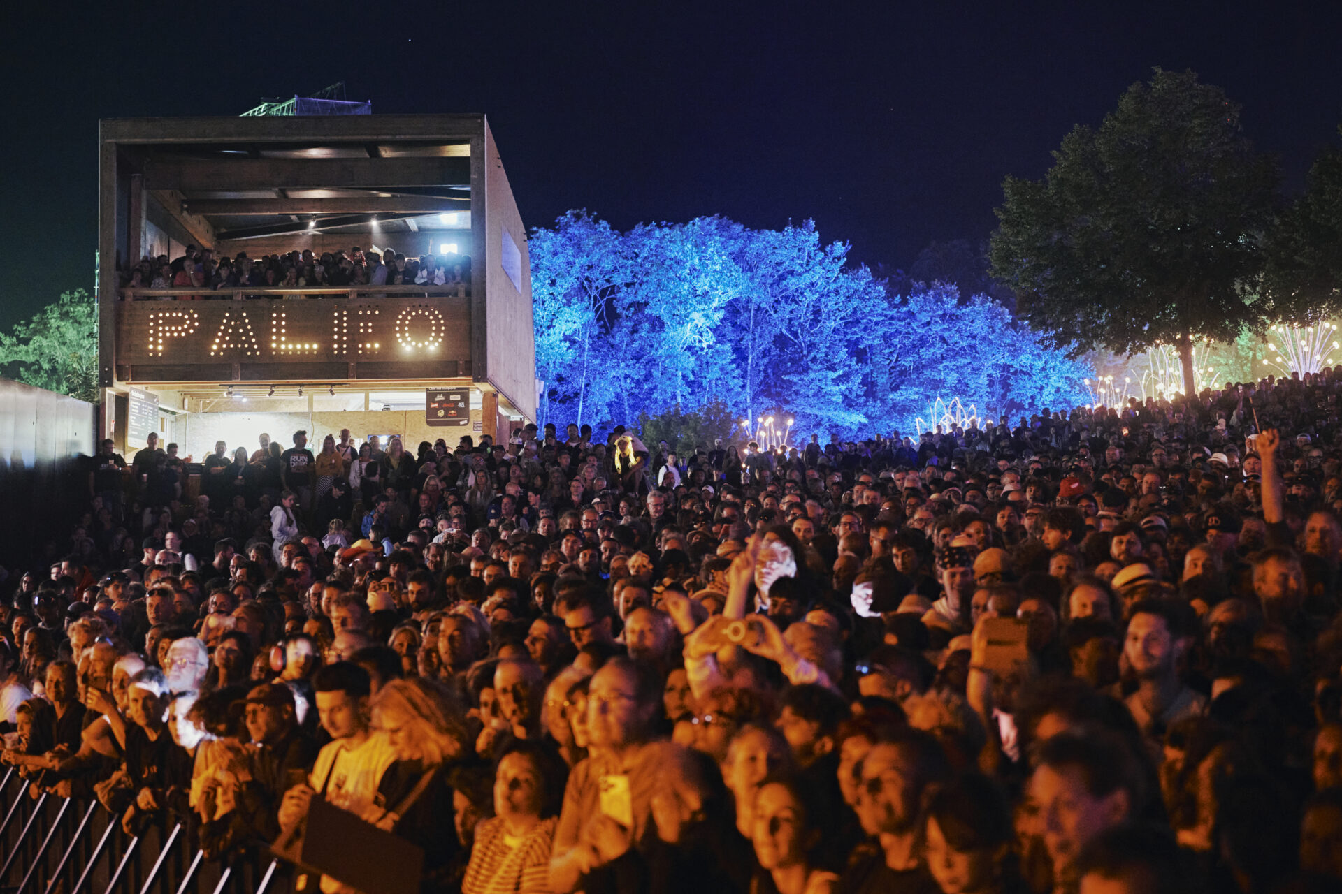 Foule dense à un festival nocturne éclairé