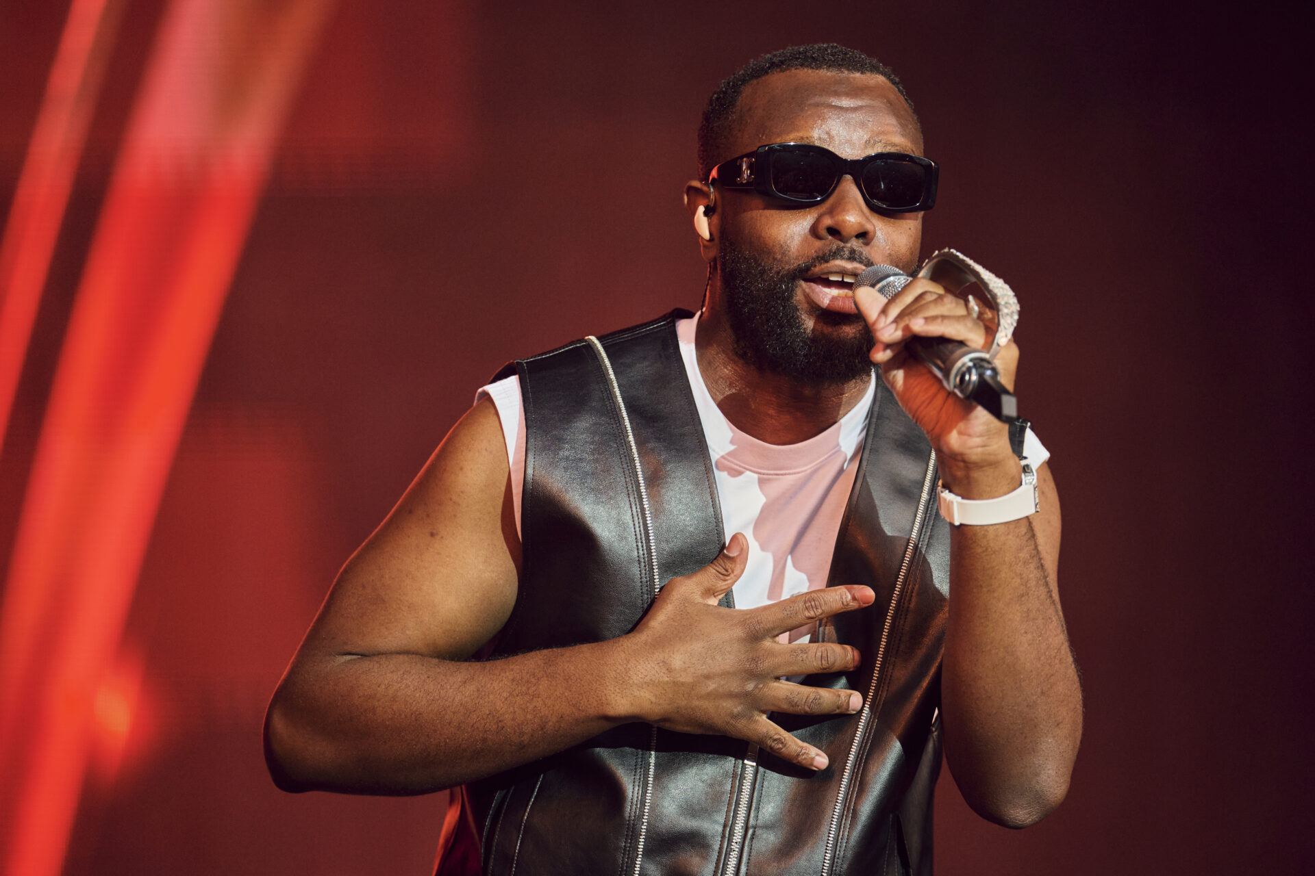 Chanteur sur scène avec micro et lunettes noires