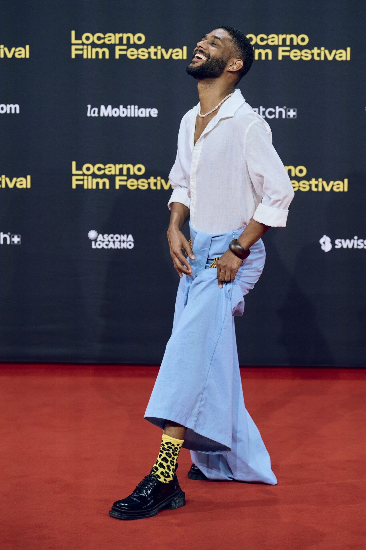 Deux hommes applaudissent sur le tapis rouge d’un festival.