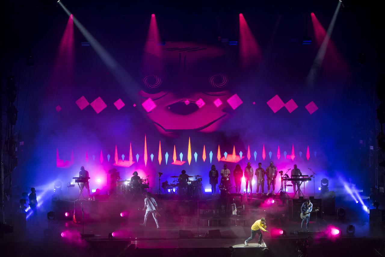 Concert sur scène aux lumières roses et violettes